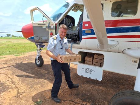 Pilot Jono Pound unloads chicks in Maridi 