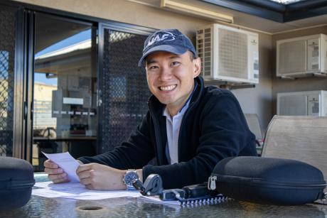 A young man smiling sitting at a table