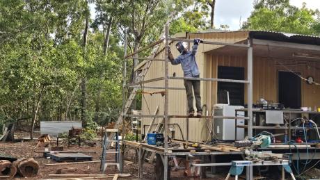 Man welding section of house frame