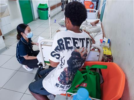 Inggrid Pinto, an MAF chaplain visits a patient and family in a hospital ward in Timor Leste.