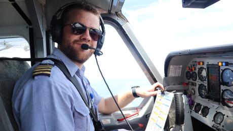 Pilot in aircraft cockpit looking into camera