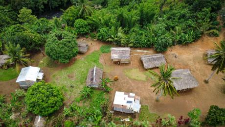Aerial view capturing the Yambaitok community’s semi-permanent houses beside the airstrip.