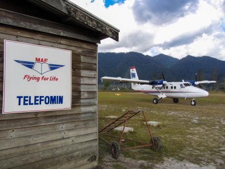 A twin engined aeroplane parked next to a remote airport building