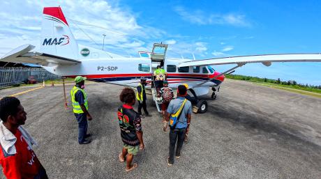 Egbert Awani with colleague Lobog Terry helping passengers
