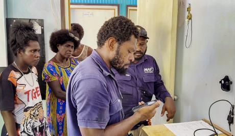 MAF Technologies technician Noah Siso testing the first HF radio call at Han Clinic, Carteret Islands.