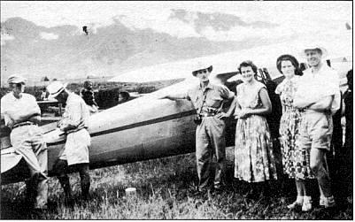 A group of people in front of a small plane