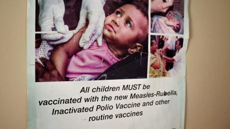 A poster showing a baby receiving an immunisation is displayed on a wall at Chuave Rural Hospital.