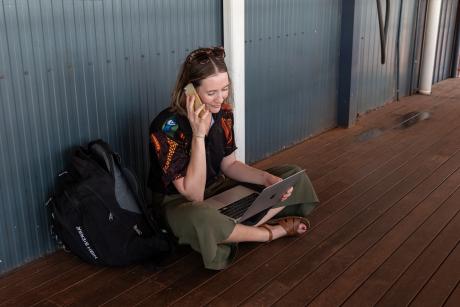 Woman seated on porch speaking on phone