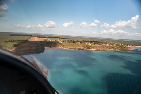 Aerial view flying over water approaching airstrip